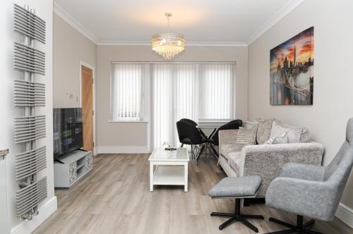 a living room with a couch and a table at Luxury 5 Star apartments, Parking, Garden, near Metro Stations 10-15mins to London in London