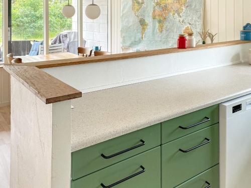 a kitchen with green cabinets and a counter top at 6 person holiday home in Ulfborg-By Traum in Ulfborg