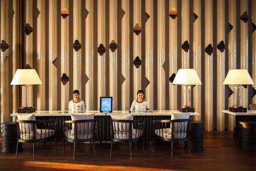 two people sitting at a table with a laptop at Hua Hin Marriott Resort and Spa in Hua Hin