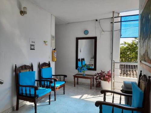 a living room with blue chairs and a mirror at Hotel Isla Capri in Mompós