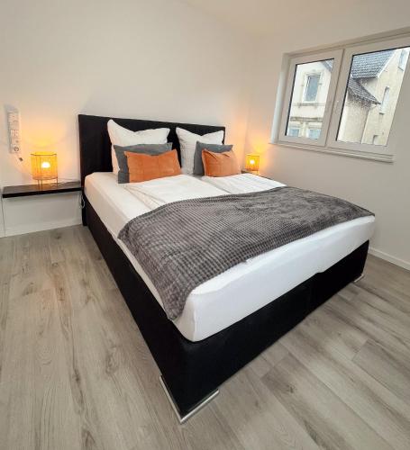 a bedroom with a large bed with two lamps on it at Home Inn Apartments - 101 in Bielefeld