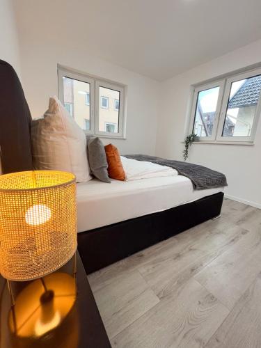 a bedroom with a bed and two windows at Home Inn Apartments - 101 in Bielefeld