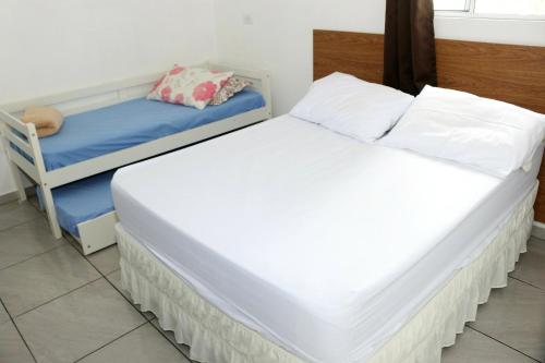 2 camas individuales en una habitación con 1 cama y 1 silla en Pousada Decarli Executiva Aeroporto Florianópolis en Florianópolis