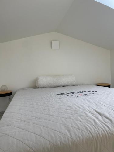 a bedroom with a white bed with a white comforter at Modern guesthouse with loft in Malmö