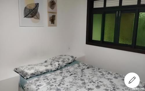 uma cama sentada num quarto ao lado de uma janela em Casa Cantinho de Buzios em Búzios