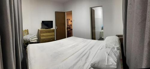 a bedroom with a white bed and a mirror at Casa en San Bernardino Py in San Bernardino