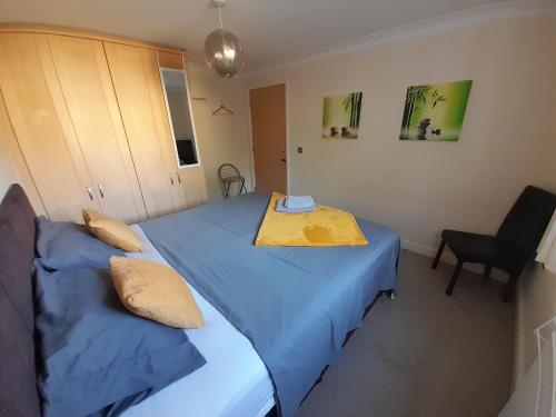 um quarto com 2 camas com lençóis azuis e uma mesa em Private rooms in a shared house in Oxford - Host lives in the property em Oxford
