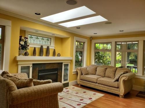 a living room with two couches and a fireplace at Elegant, Sunny Modern Home with Skylights - Kitsilano, Vancouver in Vancouver