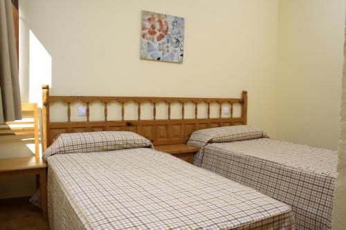 Habitación con 2 camas y una foto en la pared. en Apartamentos Tivoli, en Playa del Inglés