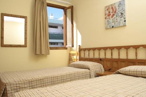 2 camas en una habitación de hotel con ventana en Apartamentos Tivoli, en Playa del Inglés