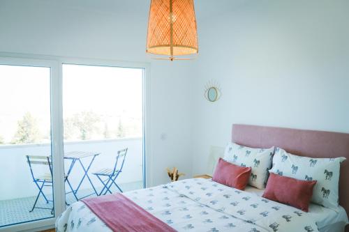 sypialnia z łóżkiem oraz balkon ze stołem w obiekcie Apartejo River Tagus View w mieście Póvoa de Santa Iria