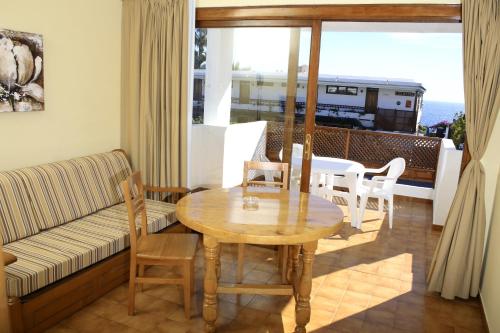 sala de estar con mesa y sofá en Apartamentos Tivoli, en Playa del Inglés