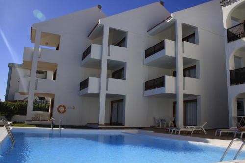 un gran edificio blanco con una piscina frente a él en Apartamentos Tivoli, en Playa del Inglés