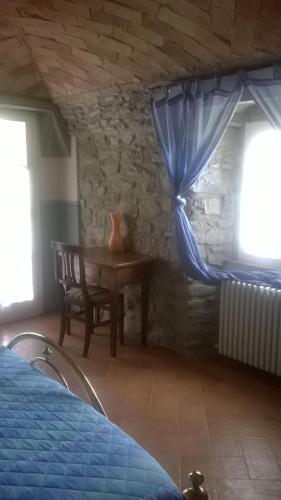 a bedroom with a table and a blue curtain at Locanda di Campagna in Mulazzo