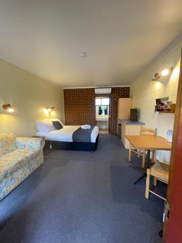 a hotel room with a bed and a desk and a table at Milawa Motel in Milawa