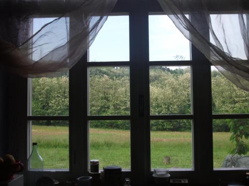 a window looking out at a field of grass at Locanda di Campagna in Mulazzo
