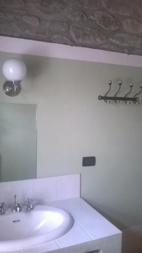 a white bathroom with a sink and a mirror at Locanda di Campagna in Mulazzo