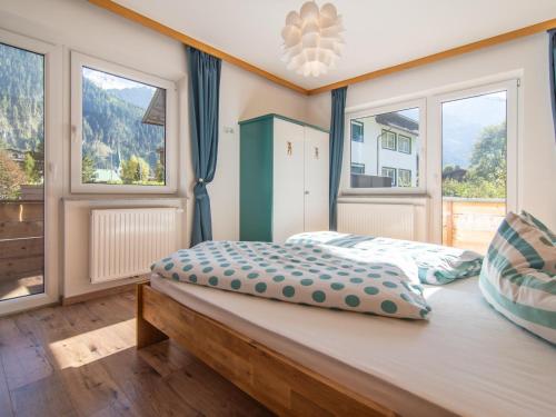 um quarto com 2 camas e 2 janelas em Regenbogenhaus em Mayrhofen