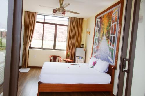 a bedroom with a white bed and a window at Anh Family Homestay in Hoi An