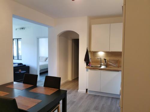 a kitchen and living room with a table and chairs at AtHome - Appart-hotel with private parking in Esch-sur-Alzette