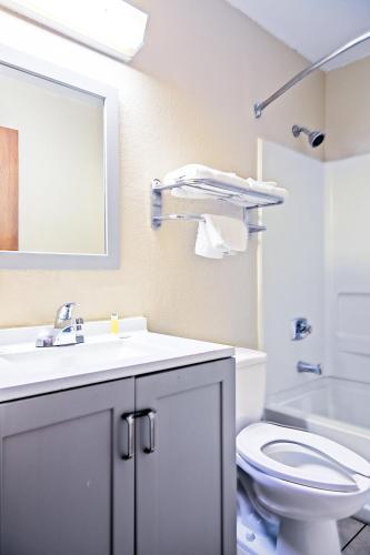a bathroom with a sink and a toilet and a mirror at Super 8 by Wyndham Augusta Ft Eisenhower Area in Augusta