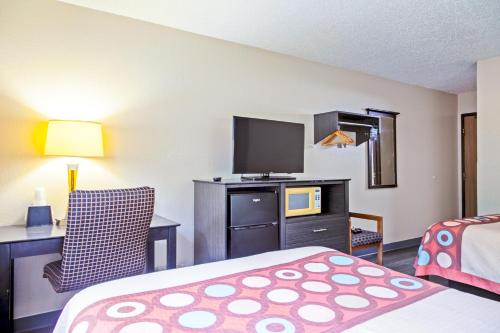 a hotel room with a bed and a flat screen tv at Super 8 by Wyndham Augusta Ft Eisenhower Area in Augusta