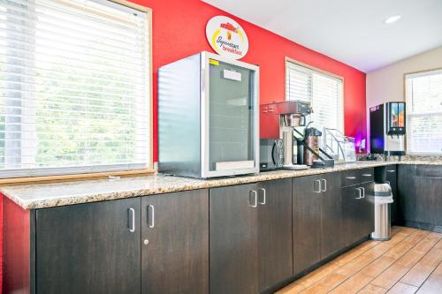 eine Küche mit einer Theke und einer roten Wand in der Unterkunft Super 8 by Wyndham Augusta Ft Eisenhower Area in Augusta