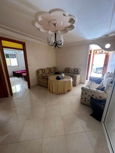 sala de estar con mesa y lámpara de araña en Rafi Apartments al Hoceima, en Alhucemas