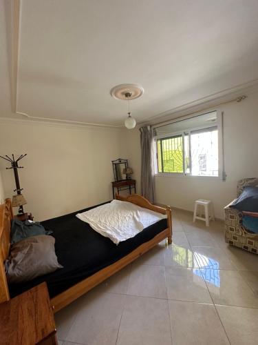 1 dormitorio con 1 cama en una habitación con ventana en Rafi Apartments al Hoceima, en Alhucemas