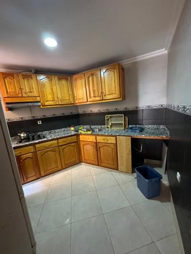 cocina con armarios de madera y encimera en Rafi Apartments al Hoceima, en Alhucemas