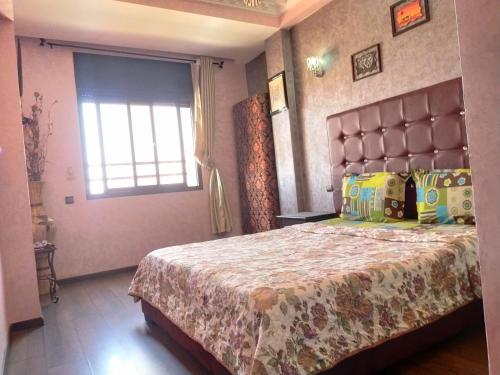 een slaapkamer met een groot bed en een raam bij MCL Majorelle Appartement in Marrakesh