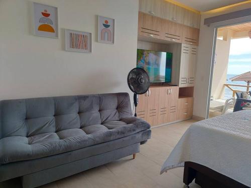 sala de estar con sofá y TV de pantalla plana en Suite privada frente al mar. en San Silvestre