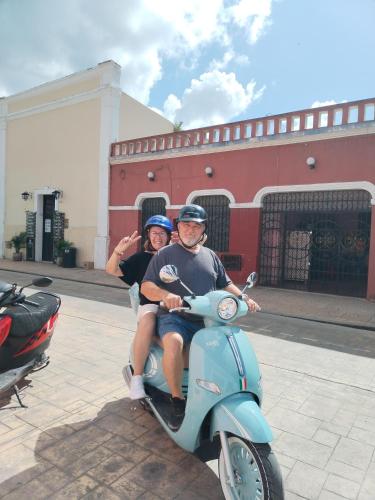 a man and a woman riding a scooter at Hostel Casa Xtakay in Valladolid