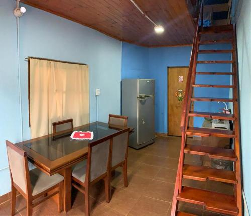 uma sala de jantar com uma mesa e um frigorífico em Hosteria NAMAJU em Puerto Iguazú
