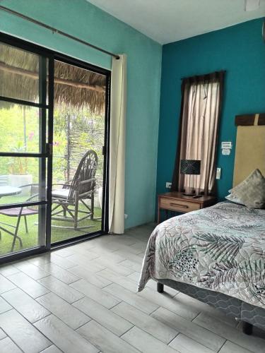 a bedroom with a bed and a table and a patio at Hostel Casa Xtakay in Valladolid