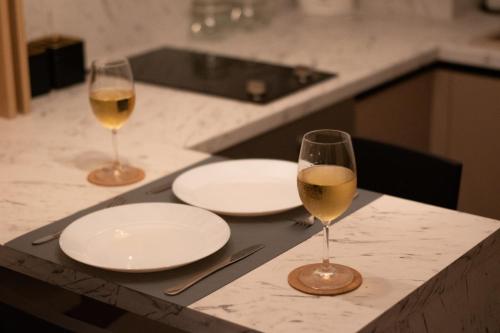 two glasses of wine sitting on a counter with plates at Bella Vista in Jagodina