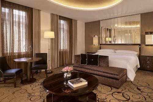 a hotel room with a bed and a couch and a table at Sheraton Grand London Park Lane in London