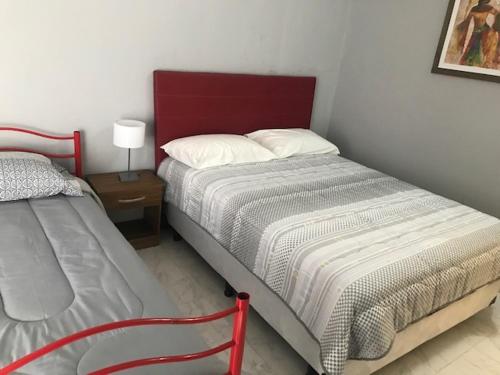 sypialnia z 2 łóżkami i czerwonym zagłówkiem w obiekcie comoencasa2 w mieście Mercedes