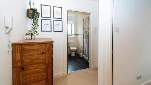 a hallway with a bathroom with a toilet and a mirror at Quayside 2-Bed Apartment in Dundee in Dundee