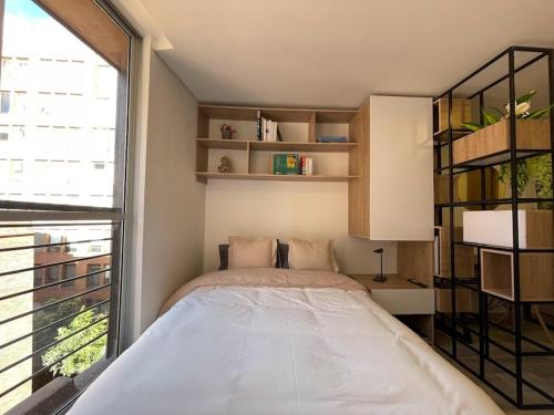 a bedroom with a bed and a large window at Loft between best business centers & restobars in Bogotá