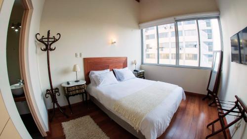 a bedroom with a white bed and a window at Atrium Miraflores Hotel in Lima