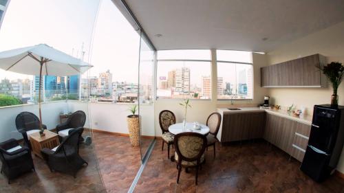 利馬的住宿－Atrium Miraflores Hotel，配有椅子和桌子的房间,有些窗户