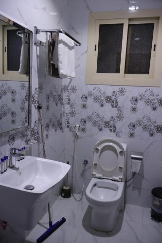 La salle de bains est pourvue de toilettes blanches et d'un lavabo. dans l'établissement جوهرة القنفذة, à Al Qunfudhah