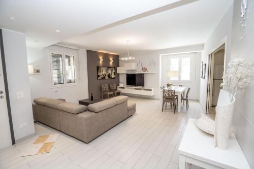 a living room and kitchen with a couch and a table at Scirocco Holiday House DIAMANTE in Rosolini
