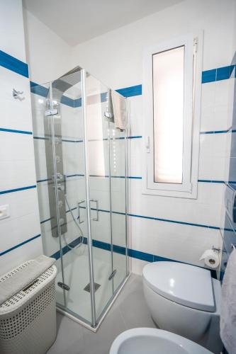 a bathroom with a toilet and a glass shower at Scirocco Holiday House DIAMANTE in Rosolini