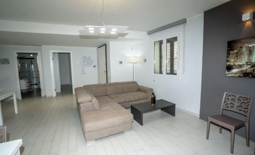 a living room with a couch and a table at Scirocco Holiday House DIAMANTE in Rosolini