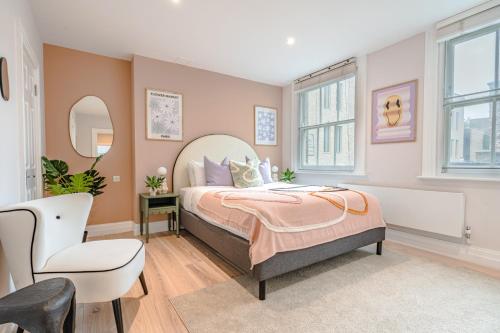 ein Schlafzimmer mit einem Bett und einem Stuhl in der Unterkunft Be London - The Soho Residences in London