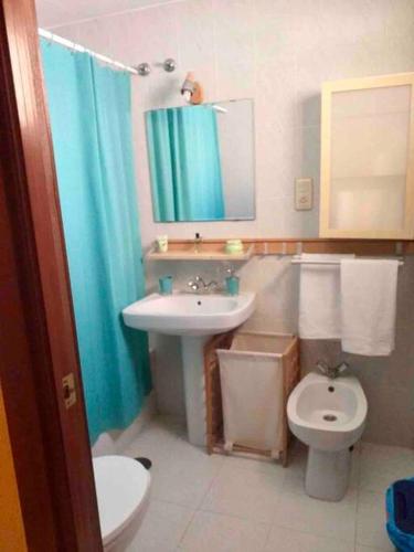 La salle de bains est pourvue d'un lavabo, de toilettes et d'un miroir. dans l'établissement Apartamento en el centro 3 plazas con Aire Acondicionado Estancia minima 3 noches, à El Puerto de Santa María
