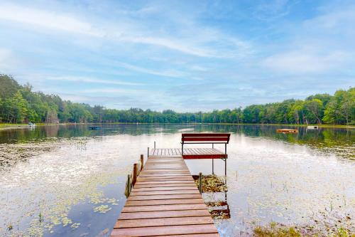 a bench sitting on a dock in the middle of a lake at Hillis House in Arbor Vitae