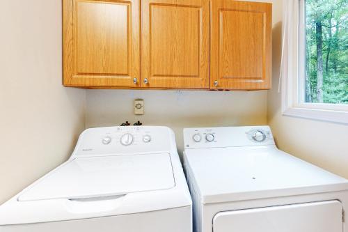 a kitchen with white appliances and wooden cabinets at Hillis House in Arbor Vitae
